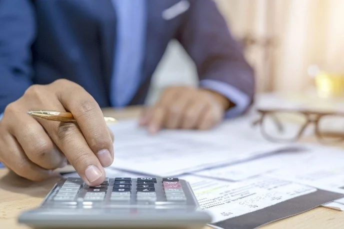 Image of a person using a calculator at a desk