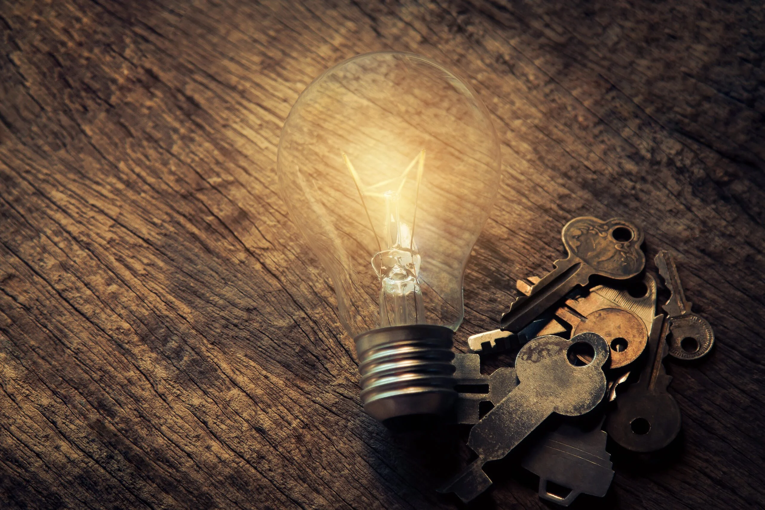 Image of a lightbulb and keys on a desk